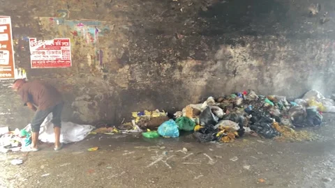 Pollution: Poor man dumping trash from plastic bag and city garbage pilled up Stock Footage 340905913