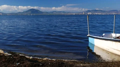 Pollution in the sea and an abandoned small fishing boat Video stock 136900522