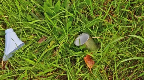 Pollution.Garbage abandoned in a meadow of grass Stock Footage 65827826
