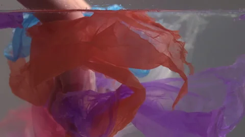 Polyethylene floats in the water close up. Various garbage bags floating in the Stock Footage 156399459