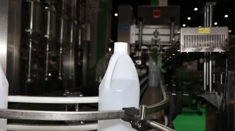Polyethylene gallon in conveyor labelling machine Stock Photos