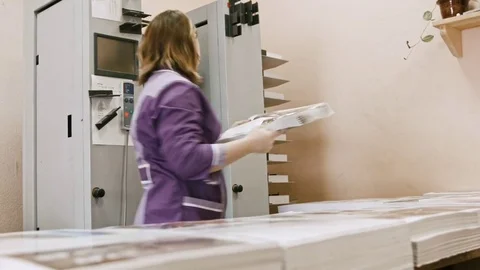 Polygraph industry - woman working on folder machine in printing house Stock Footage 74203254