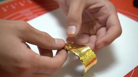 Polymer clay master stretching piece of golden foil on clay. Artisan, master Stock Footage 240950183