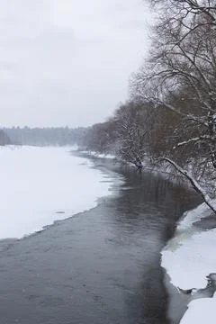 Polynya on the river on a cloudy day. Stock Photos