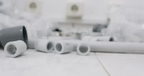 Polypropylene coupling rolls on workbench among pipe fittings Stock Footage 322012171