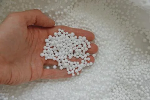 Polystyrene balls in hand. Packaging of fragile goods, filling for chair bags Stock Photos
