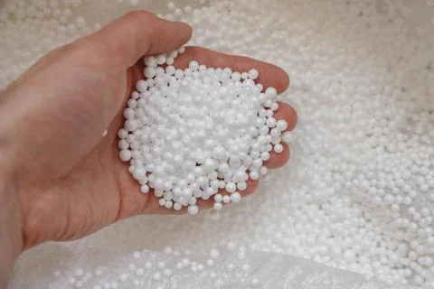 Polystyrene balls in hand. Packaging of fragile goods, filling for chair bags Stock Photos