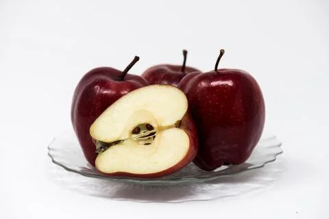 Pome fruit, three red apples whole and one cut apple on white background Stock Photos