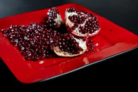Pomegranate arils macro closeup on red plate. Fresh pomegranate seeds textu.. 写真素材