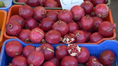 Pomegranate crates spilling ruby seeds and skin, dense red fruit piled in Stock Footage 321816705