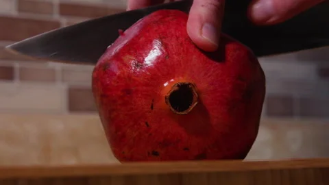 Pomegranate is Cut in Half by Woman's Hands Stock Footage 222473038