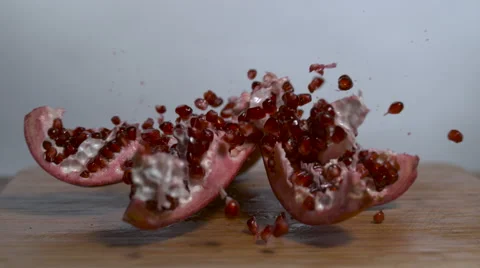 Pomegranate falls onto cutting board, exploding and releasing seeds 스톡 동영상 64282942
