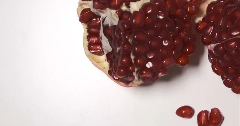 Pomegranate fruit and seeds, split open, rotating view from above on white Stock Footage 117135168