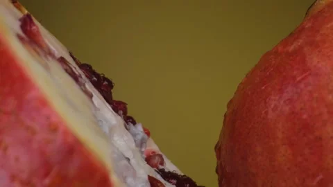 Pomegranate fruit macro shooting,isolated half kiwi on yellow background rotates Stock Footage 130995722