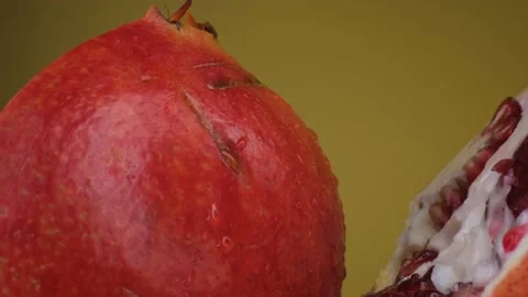 Pomegranate fruit macro shooting,isolated half kiwi on yellow background rotates Stock Footage 130995765