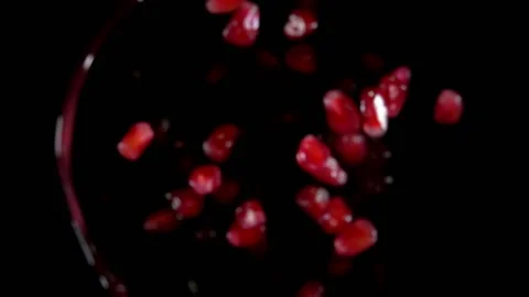 Pomegranate grains are bouncing with splashes of juice on the black background Stock Footage 127641138