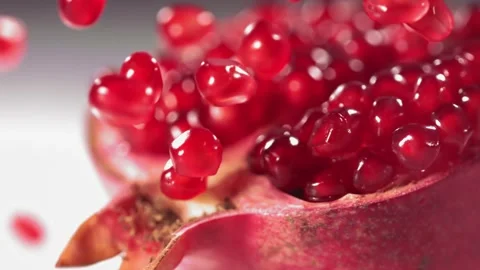 Pomegranate Grains rolls down on surface of broken pomegranate in slow motion Video stock 246479037
