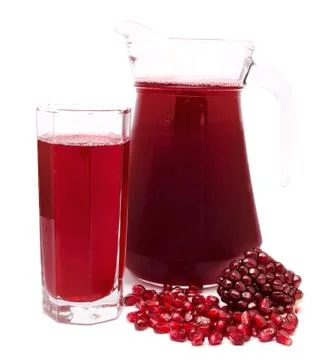 Pomegranate juice in pitcher and pomegranates isolated on white Stock Photos