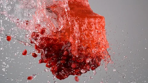 Pomegranate juice with seeds exploded and splashed in the air. Slow Motion. Stock Footage 128773091