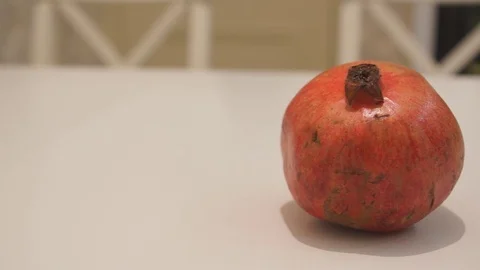 Pomegranate lies on a white kitchen table Stock Footage 71056025