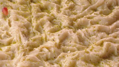 Pomegranate seeds fall down onto rose pudding (Güllaç) in slow motion. Stock Footage 147225150