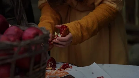 Pomegranate Split Open by Hands Revealing Red Seeds in Rural Market Stall Stock Footage 297092567