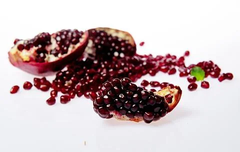 Pomegranate on white background. Pomegranate arils and halves. Healthy 库存照片