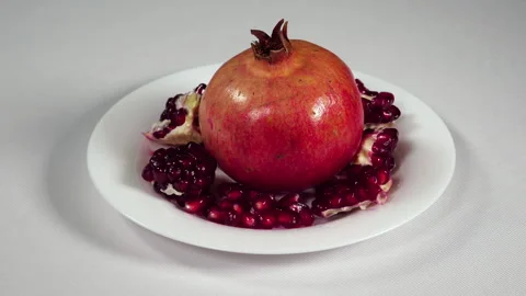 Pomegranate On White Dish in a studio Video stock 242348925
