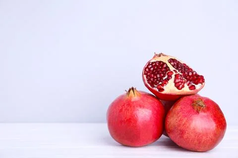 Pomegranates and half of ripe pomegranate on a grey background Stock Photos