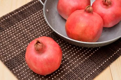 Pomegranates on a bamboo mat Stock Photos