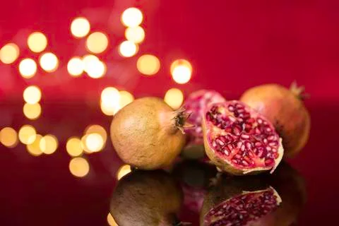 Pomegranates with reflection and blurred lights on red background Foto stock