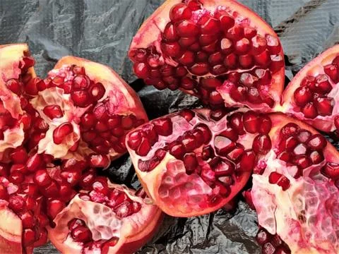 Pomegranates sliced and opened showing its blood red juicy seeds, India Stock Photos