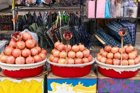 Pomegranates stacked in pyramids at Siab Bazaar in Samarkand with cut fruit.. Stock Photos