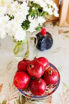 Pomegranates on the table. Beautifully decorated table with a plate of pomegr Stock Photos