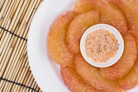 Pomelo in dish on mat Stock Photos
