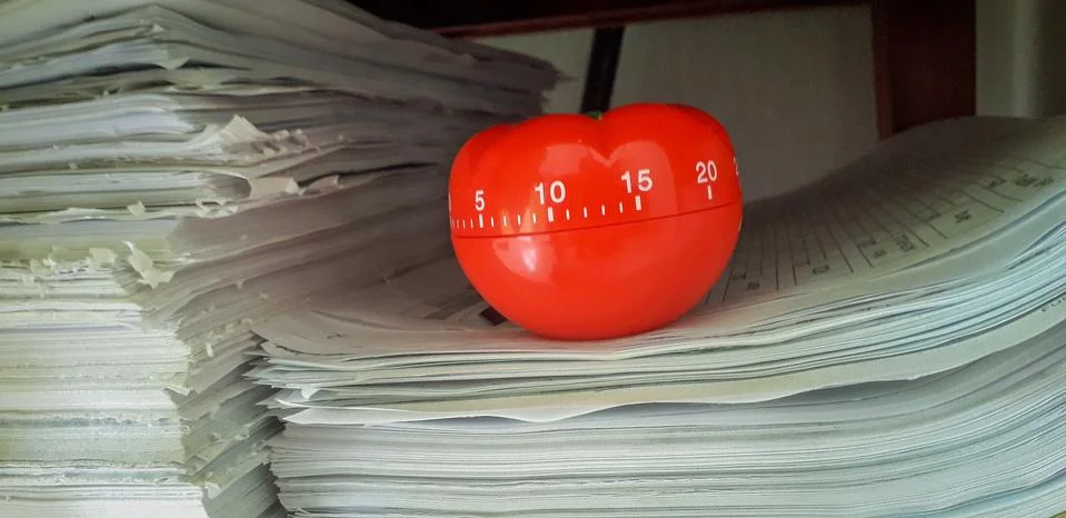 Pomodoro timer in background of paper textures piled. Stock-Fotos