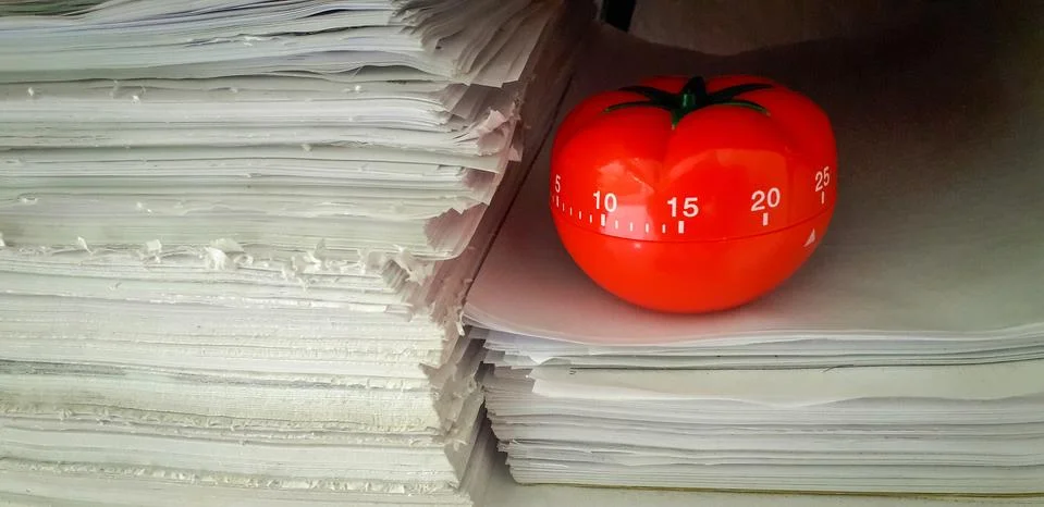 Pomodoro timer in background of paper textures piled. Stockfoto's