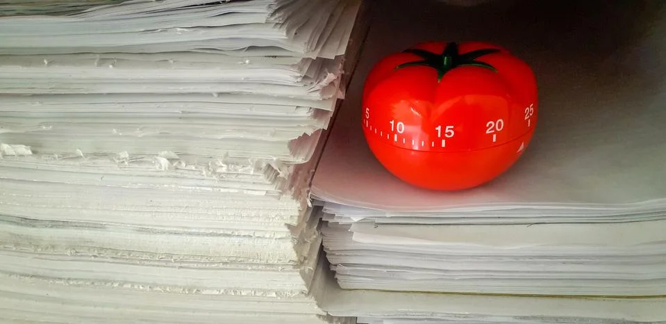 Pomodoro timer in background of paper textures piled. Stockfoto's