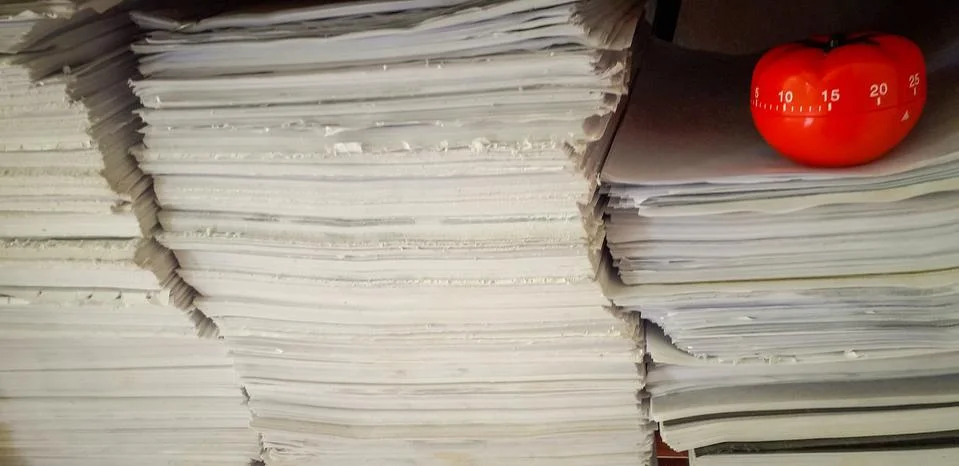 Pomodoro timer in background of paper textures piled. Stock-Fotos