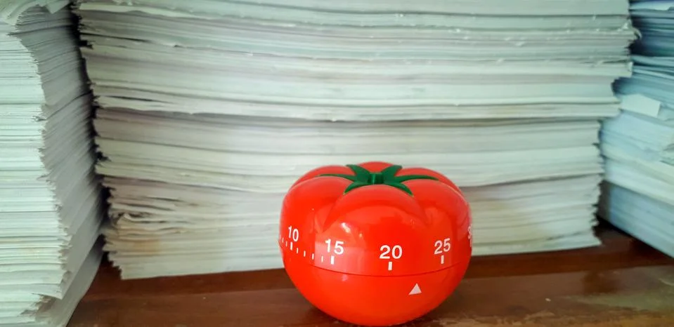Pomodoro timer in background of paper textures piled. Foto stock