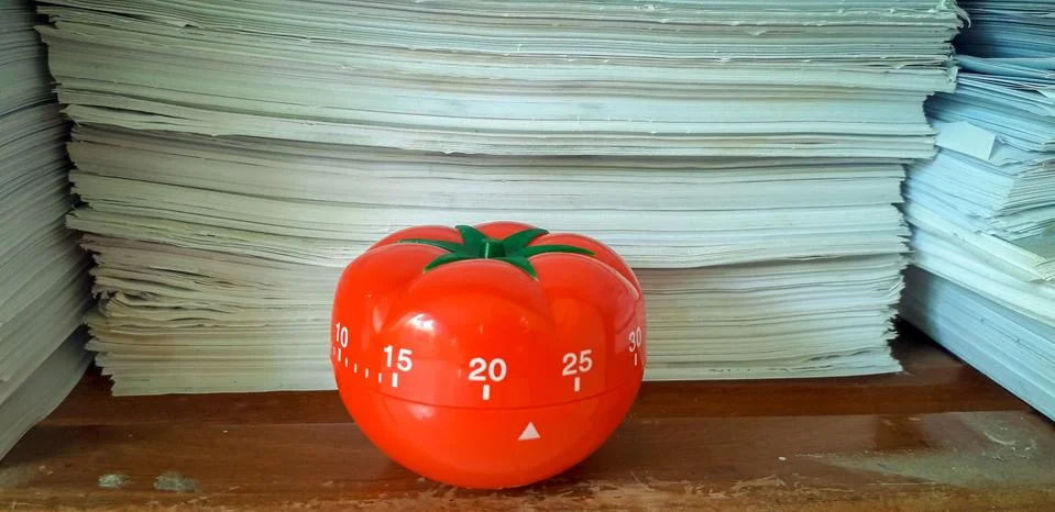 Pomodoro timer in background of paper textures piled. Stock-Fotos