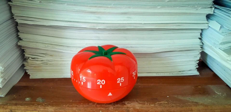 Pomodoro timer in background of paper textures piled. Foto stock
