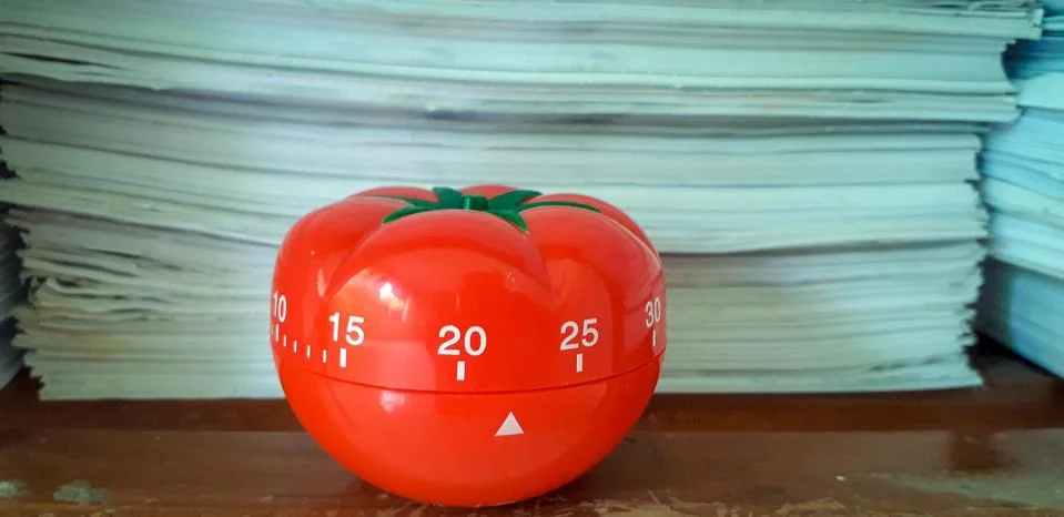 Pomodoro timer in background of paper textures piled. Stockfoto's