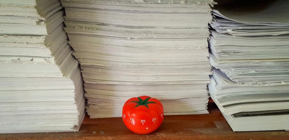 Pomodoro timer in background of paper textures piled. Stock-Fotos