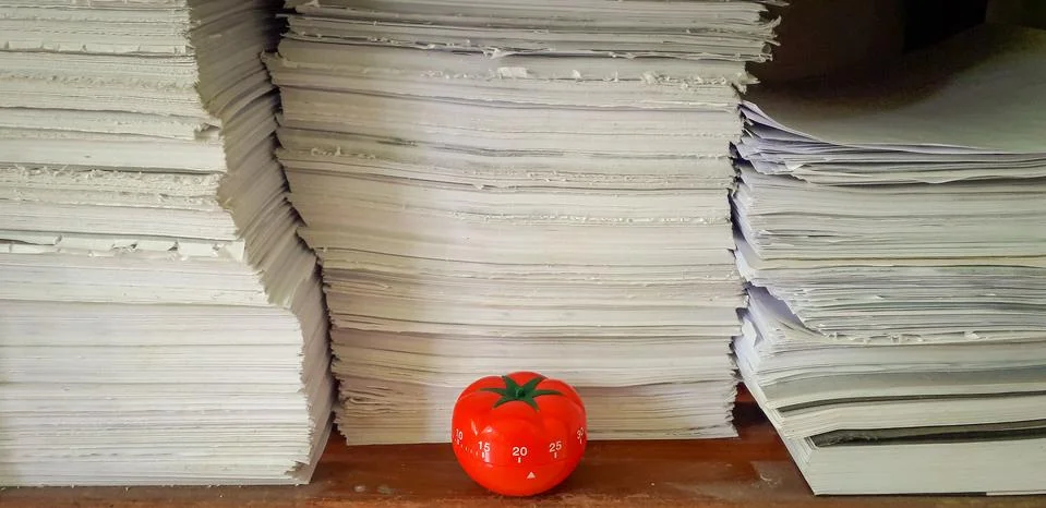 Pomodoro timer in background of paper textures piled. Stock-Fotos