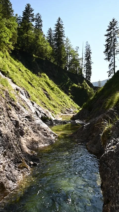 A pond inside of a v-shaped valley, vertical shot, slow motion Stock-Footage 260880032