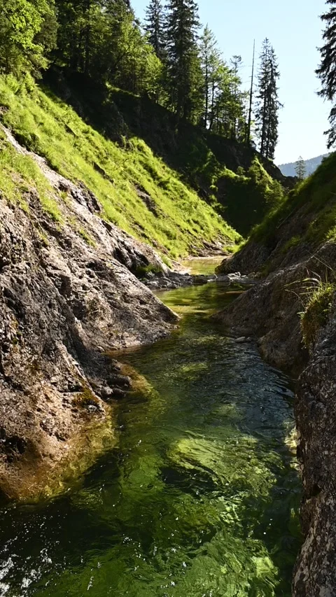 A pond inside of a v-shaped valley, vertical shot, slow motion Video stock 260880088