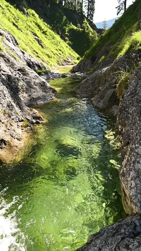 A pond inside of a v-shaped valley, vertical shot, slow motion Stock-Footage 260880136