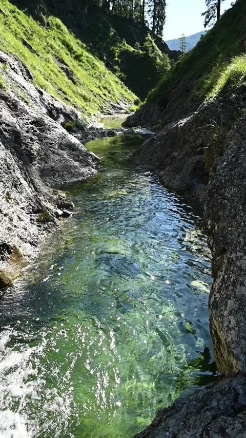 A pond inside of a v-shaped valley, vertical shot, slow motion Video stock 260880149