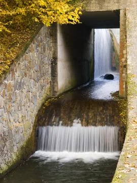 Pond outlet with small waterfall Stock Photos